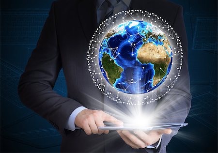 Man in suit holding tablet pc and earth in hand. Communication around the earth. The concept of communication Stock Photo - Budget Royalty-Free & Subscription, Code: 400-07419694