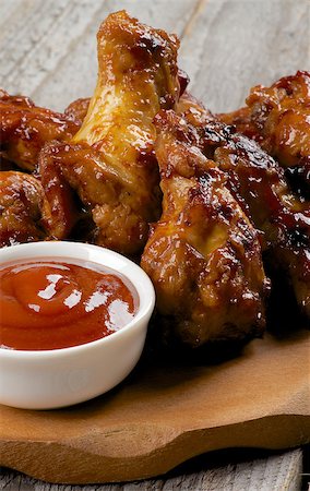 simsearch:400-08668700,k - Chicken Legs and Wings Barbecue with Ketchup on Wooden Plate closeup Photographie de stock - Aubaine LD & Abonnement, Code: 400-07410171