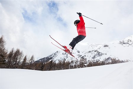 Male kid performs a high jump with the ski. Winter season, red jacket. Valle d'Aosta, Italy, Europe. Fotografie stock - Microstock e Abbonamento, Codice: 400-07410561
