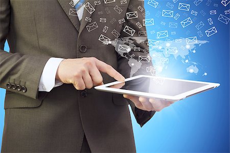 Businessman in a suit holding a tablet computer. Letters icons fly out of the tablet Fotografie stock - Microstock e Abbonamento, Codice: 400-07411515