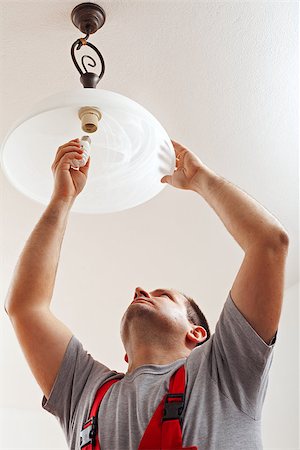 people in mountain home - Electrician finished mounting ceiling lamp - installing a fluorescent lightbulb Stock Photo - Budget Royalty-Free & Subscription, Code: 400-07412283