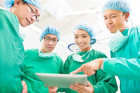 simsearch:400-07412761,k - happy Surgeons discussing success operating procedure with tablet Foto de stock - Royalty-Free Super Valor e Assinatura, Número: 400-07412774
