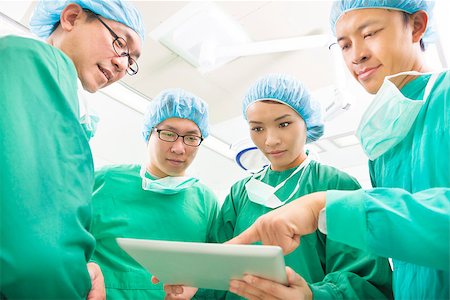 The surgeons useing  tablet  to discuss operating procedure Stock Photo - Budget Royalty-Free & Subscription, Code: 400-07412775