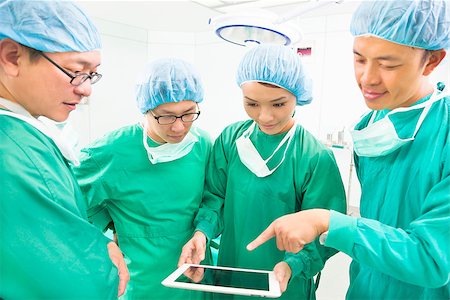 simsearch:400-07412766,k - surgeons discussing with tablet in operating theater Foto de stock - Super Valor sin royalties y Suscripción, Código: 400-07412773