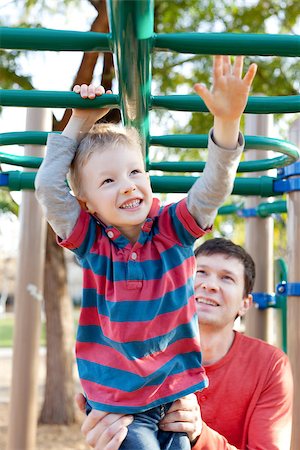 cheerful little boy playing at monkey bars and his father helping him at the playground Stock Photo - Budget Royalty-Free & Subscription, Code: 400-07413735