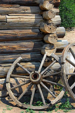 Two rustic wagon wheels lean against a log cabin wall at the El Rancho De Las Golondrinas National Historic Trail. Foto de stock - Royalty-Free Super Valor e Assinatura, Número: 400-07424413