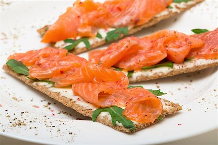 Salted salmon on crispy bread with cheese and arugula, closeup Foto de stock - Super Valor sin royalties y Suscripción, Código: 400-07424622