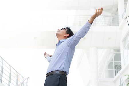 Successful Asian Indian businessman with arms outstretched celebrating his victory, modern office building as background, freedom concept. Stock Photo - Budget Royalty-Free & Subscription, Code: 400-07424754