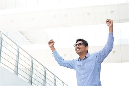 Successful Asian Indian businessman with arms up celebrating his victory, modern office building as background. Stock Photo - Budget Royalty-Free & Subscription, Code: 400-07424755