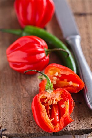 Closeup of whole and cut red and green chili peppers with knife on wooden board surface Stock Photo - Budget Royalty-Free & Subscription, Code: 400-07425556