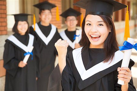 young college graduate holding diploma  and make a fist Stock Photo - Budget Royalty-Free & Subscription, Code: 400-07425873