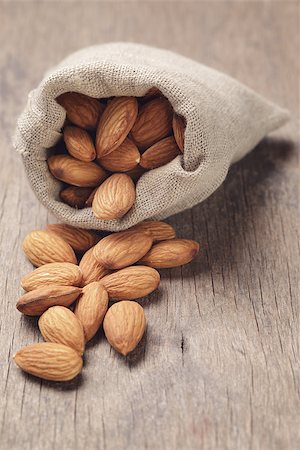 small sack bag full of almonds on wooden table, slightly toned in retro style Stock Photo - Budget Royalty-Free & Subscription, Code: 400-07426242