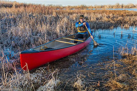 red canoe on lake - senior male paddling a red canoe through a swamp, early spring Stock Photo - Budget Royalty-Free & Subscription, Code: 400-07426822