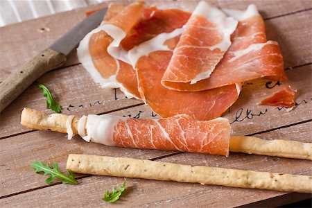 smoked ham - Grissini bread sticks with prosciutto ham and arugula on wooden board. Foto de stock - Super Valor sin royalties y Suscripción, Código: 400-07427487