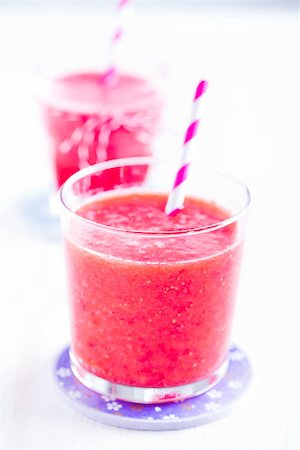 smoothie with two straws - Closeup of strawberry smoothie and striped straw in glass on purple plate with another in background Stock Photo - Budget Royalty-Free & Subscription, Code: 400-07427649