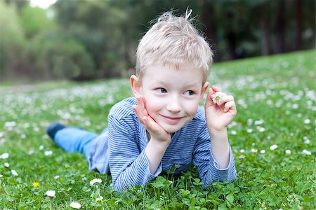 simsearch:400-06768635,k - cute smiling boy lying at grass with flowers and dreaming at summer time Foto de stock - Royalty-Free Super Valor e Assinatura, Número: 400-07428170