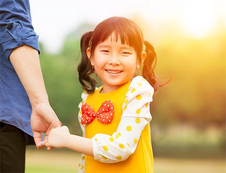 family relaxing with kids in the sun - pretty girl hold father hand  in the park with sunlight Stock Photo - Budget Royalty-Free & Subscription, Code: 400-07429895