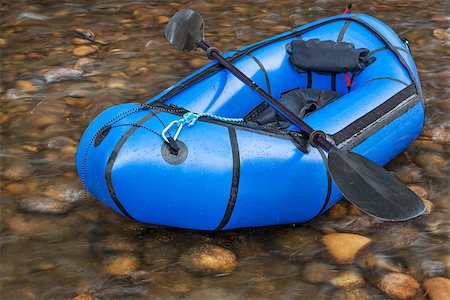 simsearch:400-07176700,k - a blue pacraft (one-person light raft used for expedition or adventure racing) with a kayak paddle against a shallow river Foto de stock - Super Valor sin royalties y Suscripción, Código: 400-07420271