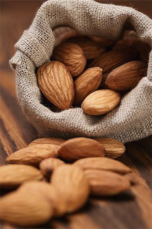 small sack bag full of almonds, on wooden table Stock Photo - Budget Royalty-Free & Subscription, Code: 400-07421346