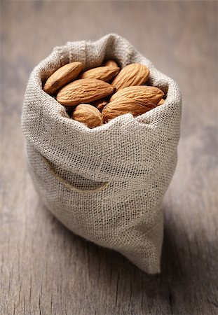 small sack bag full of almonds, on wooden table Stock Photo - Budget Royalty-Free & Subscription, Code: 400-07421347