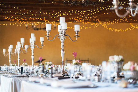 Wedding reception hall with decor including candles, cutlery and crockery; selective focus on candelabra Foto de stock - Super Valor sin royalties y Suscripción, Código: 400-07422417