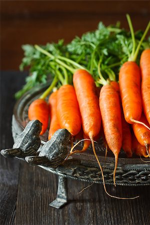 simsearch:400-07422782,k - Fresh organic kitchen garden carrots on vintage plate close-up. Photographie de stock - Aubaine LD & Abonnement, Code: 400-07445518