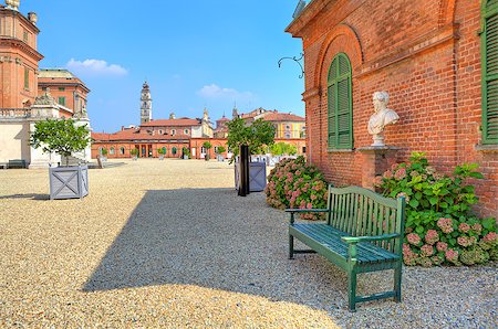 simsearch:400-05701901,k - Wooden bench on the gravel pathway next to red brick house at the entrance to park and Royal Castle of Racconigi in Piedmont, Northern Italy. Fotografie stock - Microstock e Abbonamento, Codice: 400-07445984