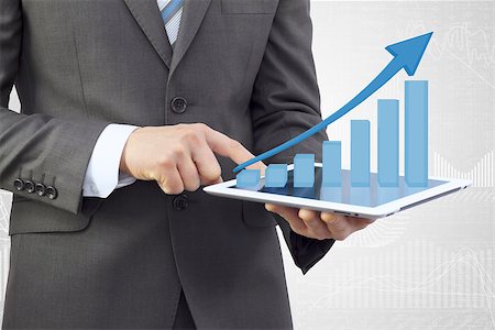 examine graphs - Businessman in a suit holding a tablet pc. Growth chart on screen tablet Stock Photo - Budget Royalty-Free & Subscription, Code: 400-07446343