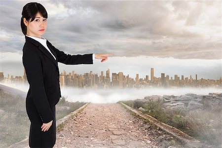 simsearch:400-07446838,k - Focused businesswoman pointing against stony path leading to large urban sprawl Photographie de stock - Aubaine LD & Abonnement, Code: 400-07446699