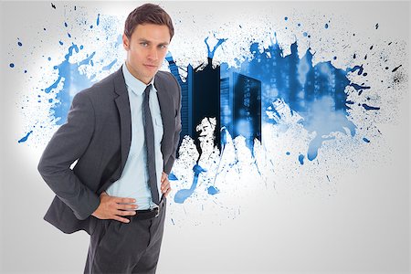 simsearch:400-07448077,k - Serious businessman standing with hands on hips against splash on wall revealing server tower Fotografie stock - Microstock e Abbonamento, Codice: 400-07446894