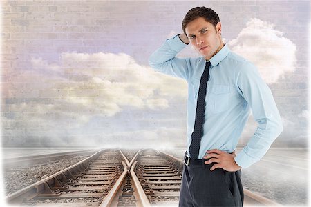 simsearch:400-07446838,k - Thinking businessman with hand on head against train tracks leading to brick wall with clouds Photographie de stock - Aubaine LD & Abonnement, Code: 400-07447461