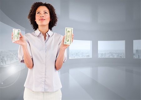Serious businesswoman holding dollars and looking upwards against bright white room with windows Stock Photo - Budget Royalty-Free & Subscription, Code: 400-07447585