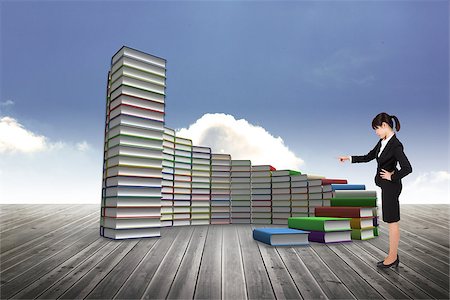 simsearch:614-02838643,k - Focused businesswoman pointing against steps made of books against sky Photographie de stock - Aubaine LD & Abonnement, Code: 400-07447944