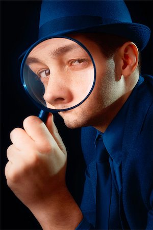 simsearch:400-04554899,k - Young man holding a magnifying glass up to his eye Stock Photo - Budget Royalty-Free & Subscription, Code: 400-07464685