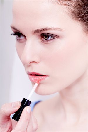 brunette attractive woman portrait applying lipstick lipgloss in beauty salon Stock Photo - Budget Royalty-Free & Subscription, Code: 400-07464988
