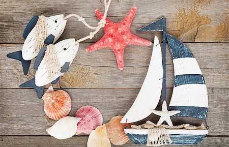 starfish beach nobody - Toy sailboat and fish with seashells and starfish on a wooden background with copy space Stock Photo - Budget Royalty-Free & Subscription, Code: 400-07465068