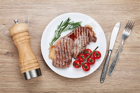 steak knife - Sirloin steak with rosemary and cherry tomatoes on a plate. View from above Photographie de stock - Aubaine LD & Abonnement, Code: 400-07465195