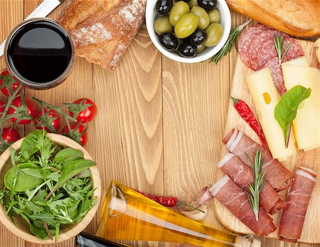 simsearch:400-07481826,k - Red wine with cheese, olives, tomatoes, prosciutto, bread and spices. Over wooden table background. View from above with copy space Stock Photo - Budget Royalty-Free & Subscription, Code: 400-07465264