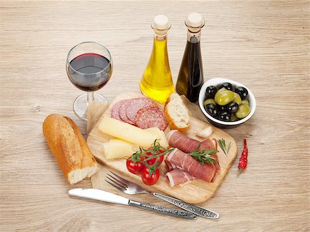 simsearch:400-07481818,k - Red wine with cheese, olives, tomatoes, prosciutto, bread and spices. Over wooden table background Foto de stock - Super Valor sin royalties y Suscripción, Código: 400-07465261