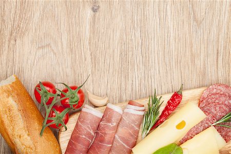 simsearch:400-07481818,k - Cheese, prosciutto, bread, vegetables and spices. Over wooden table background with copy space Foto de stock - Super Valor sin royalties y Suscripción, Código: 400-07465262