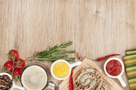 Grilled sausages with ketchup, mustard and mug of beer. Over wooden table background with copy space Stock Photo - Budget Royalty-Free & Subscription, Code: 400-07465286