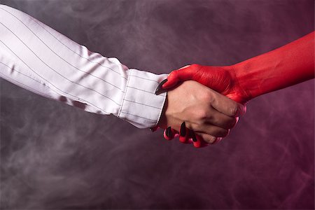 evil hand - Businessman making an agreement with devil, studio shot on smoky background Stock Photo - Budget Royalty-Free & Subscription, Code: 400-07465486