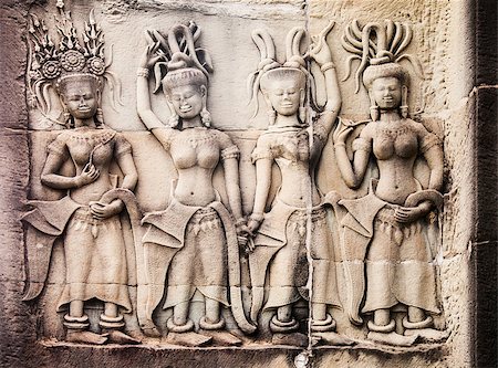 picture on wall of angkor temple - Ancient stone carvings on a wall at Angkor Wat in Cambodia depict four women standing together. They are attired similarly but are wearing fancy hats. Stock Photo - Budget Royalty-Free & Subscription, Code: 400-07466147