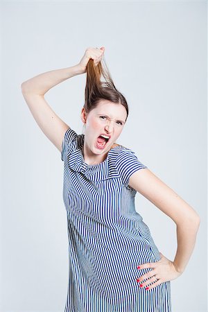 person screaming pulling hair - Studio portrait of attractive and stylish woman playfully pulling her hair while shouting Stock Photo - Budget Royalty-Free & Subscription, Code: 400-07466167