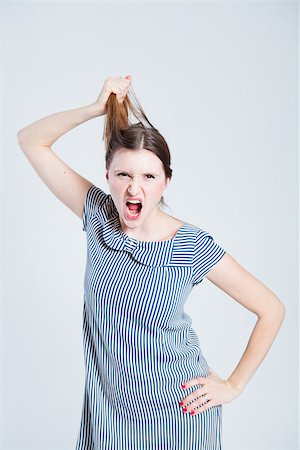 person screaming pulling hair - Studio portrait of attractive and stylish woman playfully pulling her hair while shouting Stock Photo - Budget Royalty-Free & Subscription, Code: 400-07466168