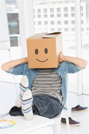 Casual young man with happy smiley box over face while sitting on chair at office Stock Photo - Budget Royalty-Free & Subscription, Code: 400-07466470