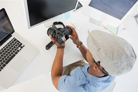 High angle view of a male photo editor looking at digital camera in his office Stock Photo - Budget Royalty-Free & Subscription, Code: 400-07466587