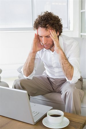 simsearch:400-07274613,k - Worried well dressed man sitting with head in hands looking at laptop in the house Stock Photo - Budget Royalty-Free & Subscription, Code: 400-07466657