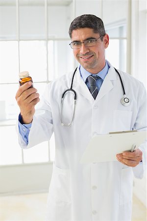 simsearch:400-04130714,k - Portrait of a smiling male doctor holding a bottle of pills in the hospital Photographie de stock - Aubaine LD & Abonnement, Code: 400-07466766