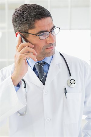 Serious male doctor using mobile phone in the hospital Stock Photo - Budget Royalty-Free & Subscription, Code: 400-07466770